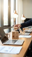Businessman stacking wooden blocks with business icons on office desk near laptop representing teamwork strategy and corporate growth planning.