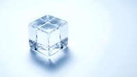 Crystal clear ice cube with perfect geometric edges isolated on white background for beverage and cooling concepts.