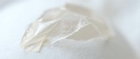Translucent plastic wrap crumpled on white surface, isolated design element for packaging, product mockups, and commercial applications.