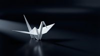 White origami paper crane on dark surface with dramatic lighting and shadows creating minimalist artistic composition for meditation and zen concepts.
