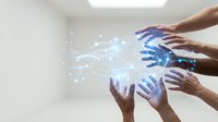 Diverse hands reaching toward glowing digital network connections in modern office space representing teamwork and technological collaboration.