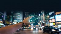 Hand holding smartphone with digital network connections overlay against blurred city lights at night showcasing modern technology and connectivity.