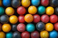 Colorful vintage wooden croquet balls arranged in pattern showing red, yellow, blue, and black spheres with weathered textures and natural aging marks.