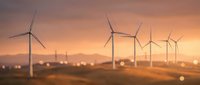 Wind turbines generating clean renewable energy at sunset with warm golden light and bokeh effects across rural landscape for sustainable power concepts.