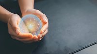 Hands holding glowing crystal ball with golden light, symbolizing future vision, fortune telling, and mystical energy for spirituality and divination concepts.