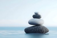 Balanced zen stones pyramid on blue background with reflection. Minimalist composition of stacked pebbles symbolizing harmony, meditation and wellness.