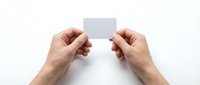 Two hands holding blank white business card isolated on white background, ready for branding and corporate design mockups.