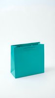 Turquoise shopping bag isolated on white background for retail, commerce and gift packaging design projects.