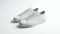 Pair of clean white leather low-top sneakers on light background, minimalist casual footwear for fashion and lifestyle concepts.