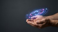 Mature male hands holding a glowing holographic galaxy with orbiting planets, neon blue and pink light, dark background, copy space.
