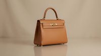 Cognac leather handbag with gold hardware and structured silhouette, isolated on neutral background for fashion, retail, and accessory design projects.