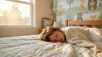 Young woman peacefully sleeping in cozy bedroom with morning sunlight streaming through window, comfortable bed with soft bedding and children's wallpaper.