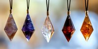 Five colorful crystal diamond-shaped pendants hanging on black cords displaying purple, blue, clear, red and amber gemstone colors for jewelry making.