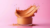 Dynamic splash of liquid foundation makeup bursting from cosmetic container against pink background, creating artistic motion capture of beauty product.