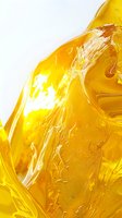 Flowing golden honey abstract macro background with dynamic swirls and ripples creating natural organic patterns in bright amber liquid.