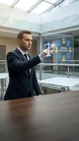Professional lawyer in dark suit interacting with holographic legal services interface displaying scales of justice in modern office environment.