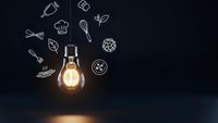 Glowing light bulb with culinary icons on dark background representing cooking creativity and kitchen innovation concepts for restaurant business.
