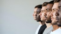 Diverse group of professional men in profile view standing together in modern office environment for business teamwork and collaboration concepts.