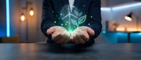 Businessman holding glowing green plant hologram in cupped hands representing sustainable business growth and environmental responsibility in modern office.