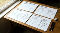 Hand tracing worksheets for children learning activities with pencils on wooden desk. Educational preschool development materials for fine motor skills practice.