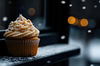 Cupcake with caramel frosting and sprinkles on dark slate surface with bokeh lights, suitable for bakery, dessert, and food photography projects.