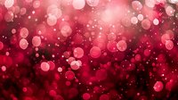 Dreamy red bokeh lights creating romantic atmosphere with blurred glowing circles and sparkles on dark background, suitable for festive designs and holiday cards.