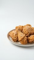 Crispy golden fried chicken pieces served on a ceramic plate against a clean white background, ready for food photography, restaurant menus, and culinary content.