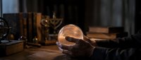 Glowing crystal ball resting on wooden surface with mystical candlelit ambiance, perfect for spirituality and fortune telling concepts.