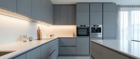Modern minimalist kitchen with gray cabinets, white countertops and built-in appliances. Contemporary interior design for home renovation projects.