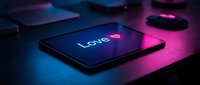 Tablet on dark desk glowing with neon pink and blue light displaying Love with a heart symbol, romantic digital concept for Valentine's Day.