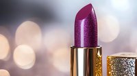 Metallic purple lipstick with glitter texture on blurred bokeh background. Luxury cosmetic product close-up shot showcases shimmer finish and golden packaging.