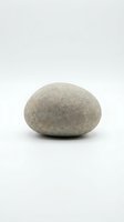 Single smooth gray pebble stone isolated on white background for zen meditation spa wellness design concepts and natural decoration projects.