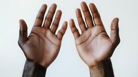 Two open hands with palms facing forward in surrender or stop gesture, showing different skin tones representing diversity and unity in human connection.
