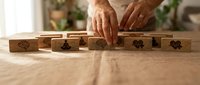 Businessman hands arranging wooden blocks with gear icons on desk representing teamwork strategy and business process management concepts.