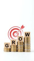 Wooden blocks spelling GROW on ascending coin stacks with red target and arrow, symbolizing financial growth and investment success on white background.