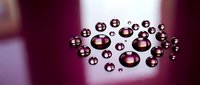 Shiny metallic spheres and bubbles scattered on a soft purple gradient background, reflecting light for abstract design, technology, or luxury concepts.