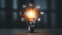 Glowing light bulb with business icons representing innovation, creativity and strategic thinking for corporate presentations and marketing materials.