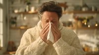 Middle-aged Caucasian man sneezing into tissue at home, cold flu symptoms, seasonal illness healthcare concept for medical wellness campaigns.