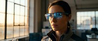 Professional woman wearing smart glasses with digital interface display in modern office environment for technology and innovation concepts.