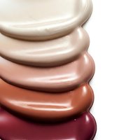 Cosmetic foundation makeup samples in various skin tones from light to dark creating color palette for beauty industry and skincare products.