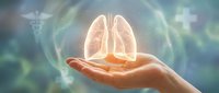 Human hand holding glowing lungs with medical symbols in background representing respiratory health care and pulmonary medicine concept.