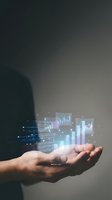 Hand holding holographic data visualization charts and graphs with glowing analytics dashboard floating above palm for business intelligence presentation.
