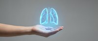 Human hand holding glowing blue lungs hologram representing respiratory health, medical care and pulmonary system protection concept.