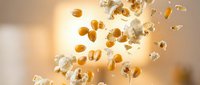 Floating golden coins and transparent diamonds scattered in bright warm light creating luxury wealth and prosperity concept for financial success designs.