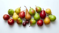 Assorted fresh apples, pears, and cherries arranged on white background, isolated produce for healthy eating, nutrition, and culinary design projects.