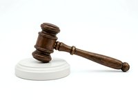 Wooden judge gavel with white circular base, isolated on white background, suitable for law, legal services, court, justice, and business design projects.