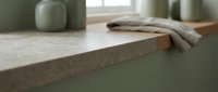 Modern kitchen countertop with gray stone surface, ceramic vessels, and linen cloth. Minimalist interior design styling for home decor and renovation projects.