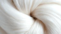 Luxurious white silky hair texture in macro shot showing smooth, glossy strands twisted in spiral pattern, creating elegant flowing curves and highlights.