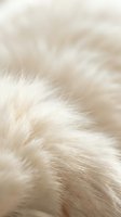 Soft cream and beige animal fur texture with fine silky strands creating natural organic pattern for luxury fashion and textile design backgrounds.