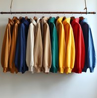 Colorful hooded sweatshirts hanging on wooden rack against white wall. Collection of casual sportswear in brown, blue, white, green, yellow, and red shades.